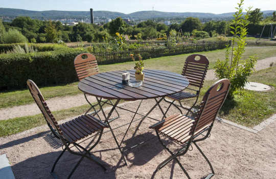 Blick vom Kaiserberg auf die Stadt. Im Vordergrund sieht man einen Holztisch mit vier Stühlen. © view - die agentur 