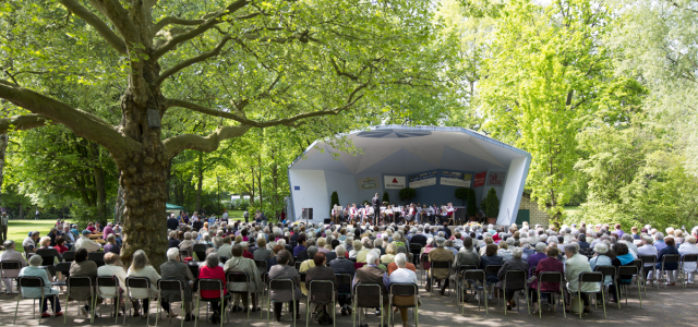 Das Volksparkkonzert im Blauen Pavillon ist gut besucht von Senioren und Seniorinnen. EIne Blumenpracht gibt dem Ganzen einen frühlingshaften Flair.