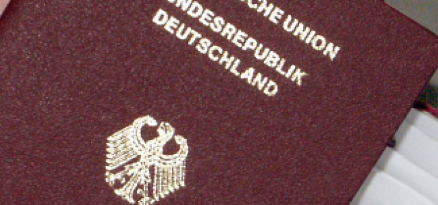Das Bild zeigt einen neuen Reisepass der Bundesrepublik Deutschland, der gerade aus einer Schublade mit mehreren beantragten Reisepässen gezogen wird.