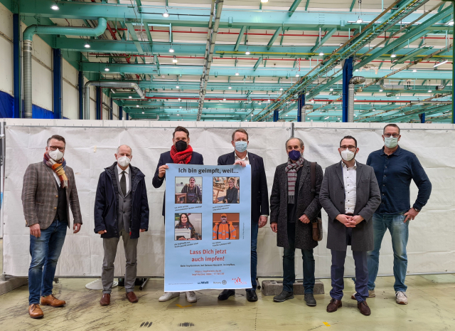Das Bild zeigt die Organisatoren der Kampagne gemeinsam mit Ministerialdirektor Daniel Stich und dem städtischen Impfkoordinator Thomas Strottner. v.l.n.r.: Michael Thome (Firma Wall), Prof. Manfred Dahm (Chefarzt Westpfalzklinikum), Daniel Stich, Christoph Dammann (Leiter Referat Kultur), Willi Schattner  (Geschäftsführer ASZ) Peer Beintner (Firma Wall), Thomas Strottner. © Ray Albuquerque