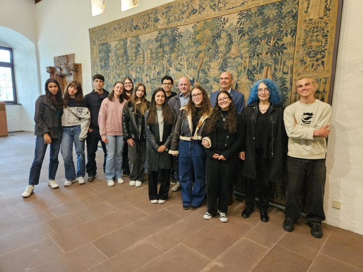 Die Schülergruppe vor dem Wandteppich im Pfalzgrafensaal mit Bürgermeister Manfred Schulz und Norbert Herhammer. © Stadt Kaiserslautern