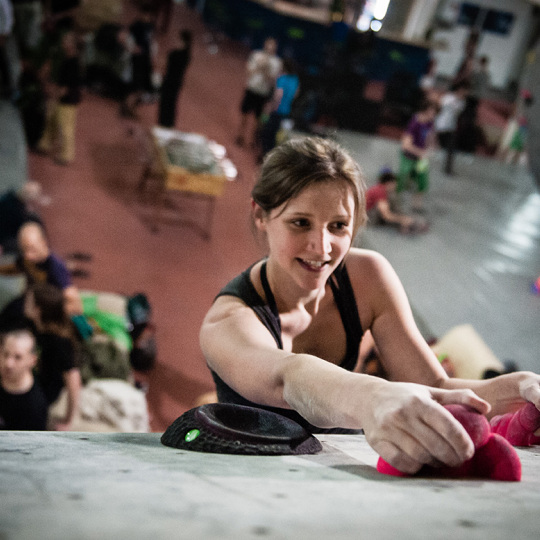 Blick von oben in Boulderhalle mit Sportlerin an der Boulderwand