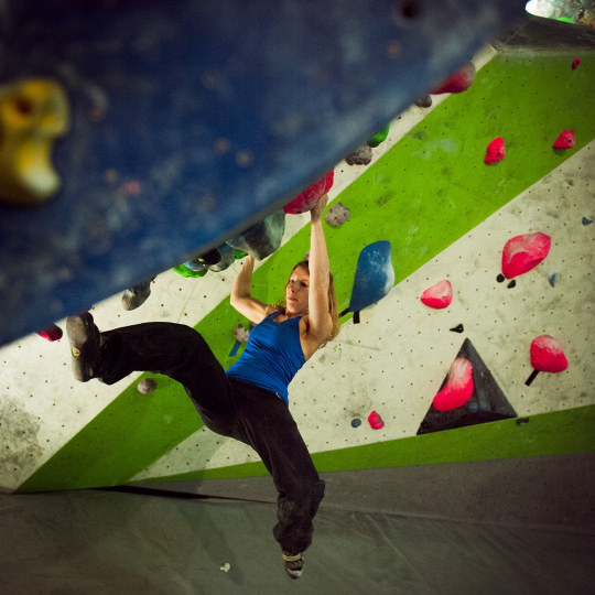 Sportlerin an Boulderwand