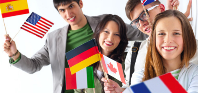 vier Jugendliche schwenken internationale Fähnchen