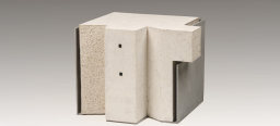 Eine helle Keramikskulptur, die aus verschiedenen geometrischen Formen besteht. Außen entlang ist eine graue Platte, die sich um die Form legt.