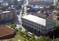Die Seitenansicht der Fruchthalle von schräg oben, die umgeben wird von grünen Parkanlagen.