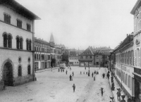 Eine schwarz-weiß Aufnahme vom Schillerplatz. Noch ist die große Verkehrsstraße nicht zu sehen und der komplette Platz ist mit Steinen gepflastert.