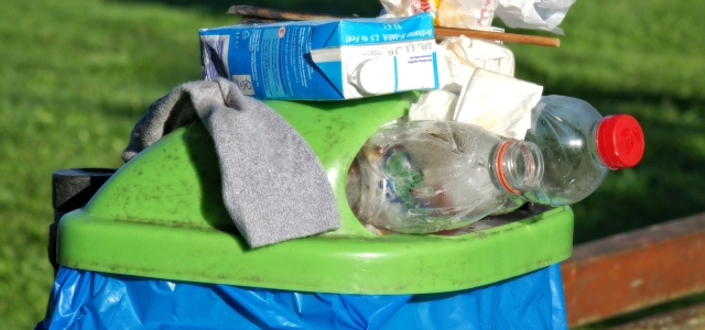 Überfüllter Mülleimer im Park.