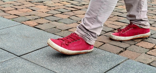 Das Bild zeigt Füße auf Pflastersteinen.